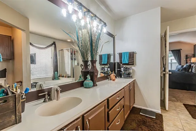 a bathroom with a sink and mirror with bathtub