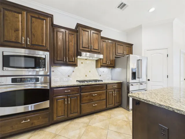 a kitchen with stainless steel appliances granite countertop a stove microwave and cabinets