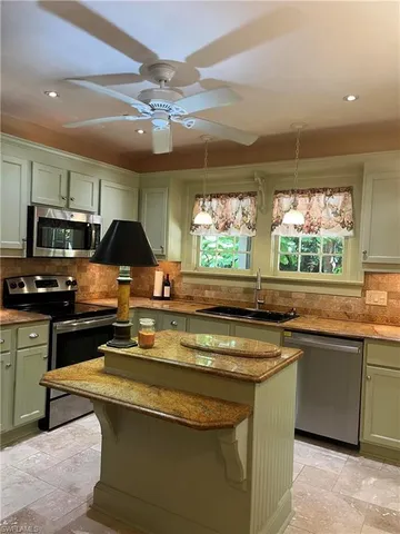 a kitchen with stainless steel appliances a sink a stove and a microwave