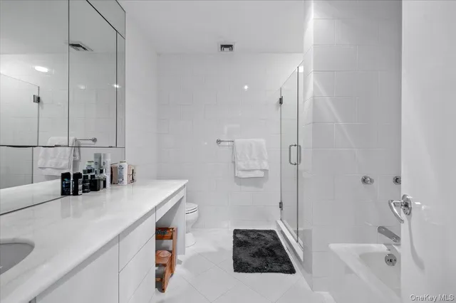 a bathroom with a sink vanity granite tub shower and mirror
