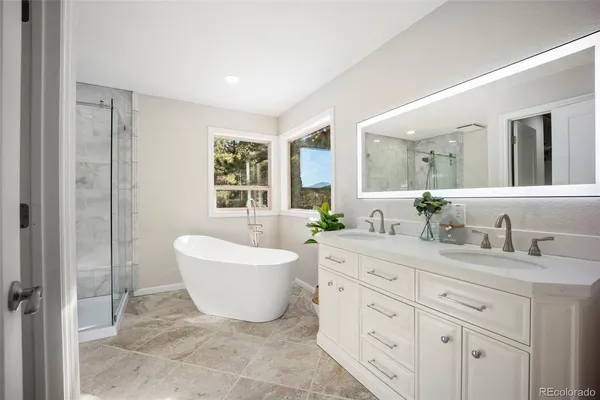 a spacious bathroom with a double vanity sink a mirror and a bathtub