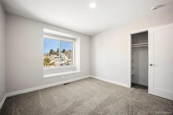 an empty room with window and ceiling fan