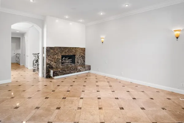 an empty room with wooden floor fire place and windows