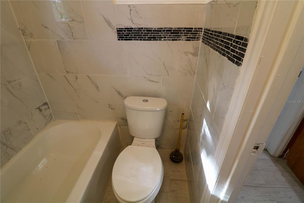 1518 Indiana Street Orlando, FL 32805 - Photo 15 of 17 a bathroom with a toilet and a bathtub