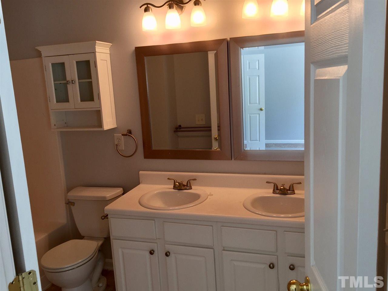 8511 Mt Valley Lane Raleigh, NC 27613 - Photo 15 of 25 a bathroom with a sink a toilet and mirror