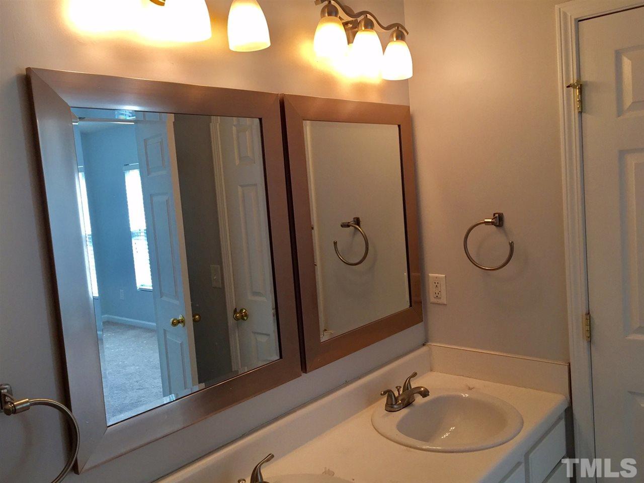8511 Mt Valley Lane Raleigh, NC 27613 - Photo 16 of 25 a bathroom with a sink and mirror with toilet