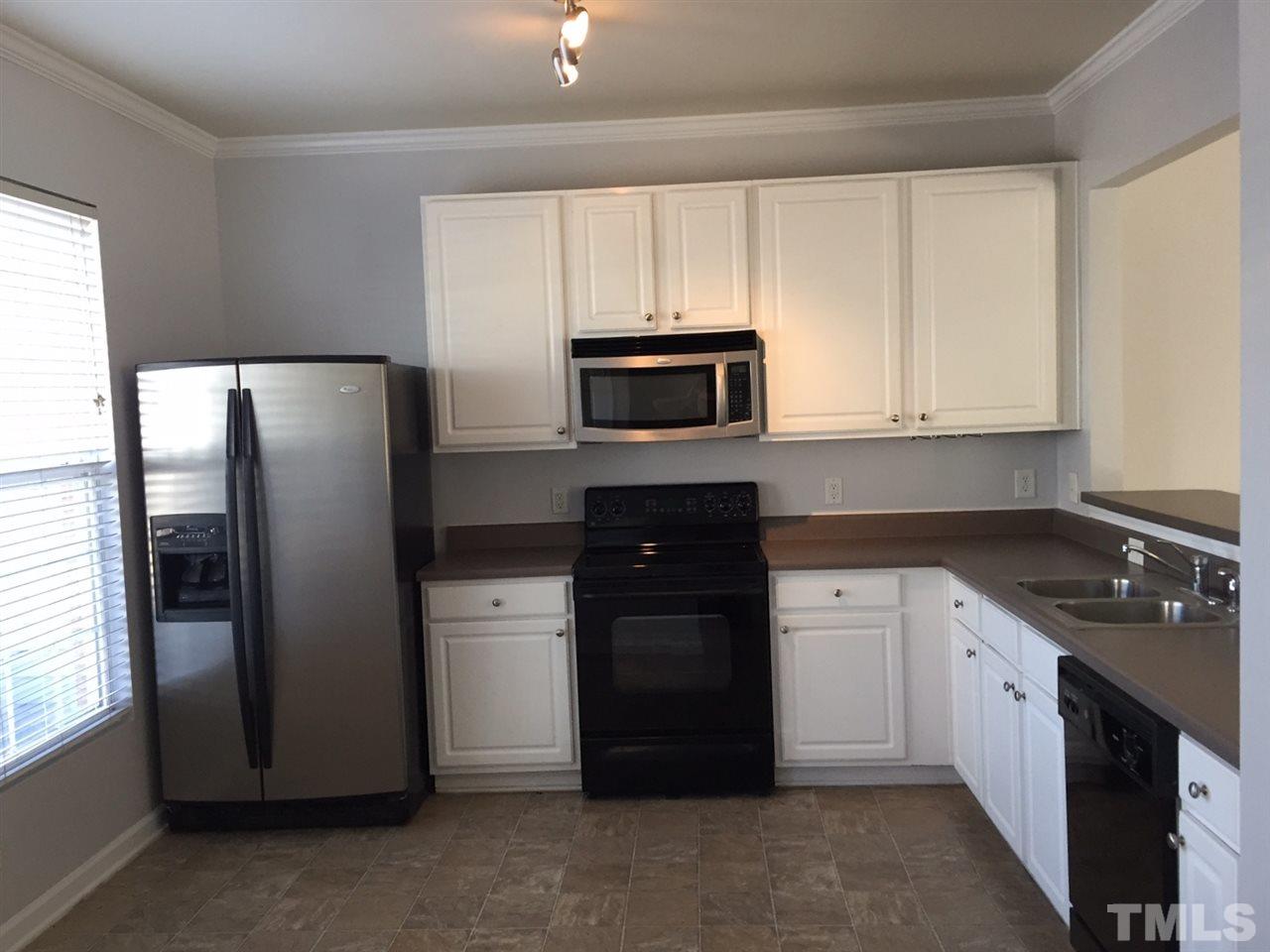 8511 Mt Valley Lane Raleigh, NC 27613 - Photo 4 of 25 a kitchen with a refrigerator sink and microwave