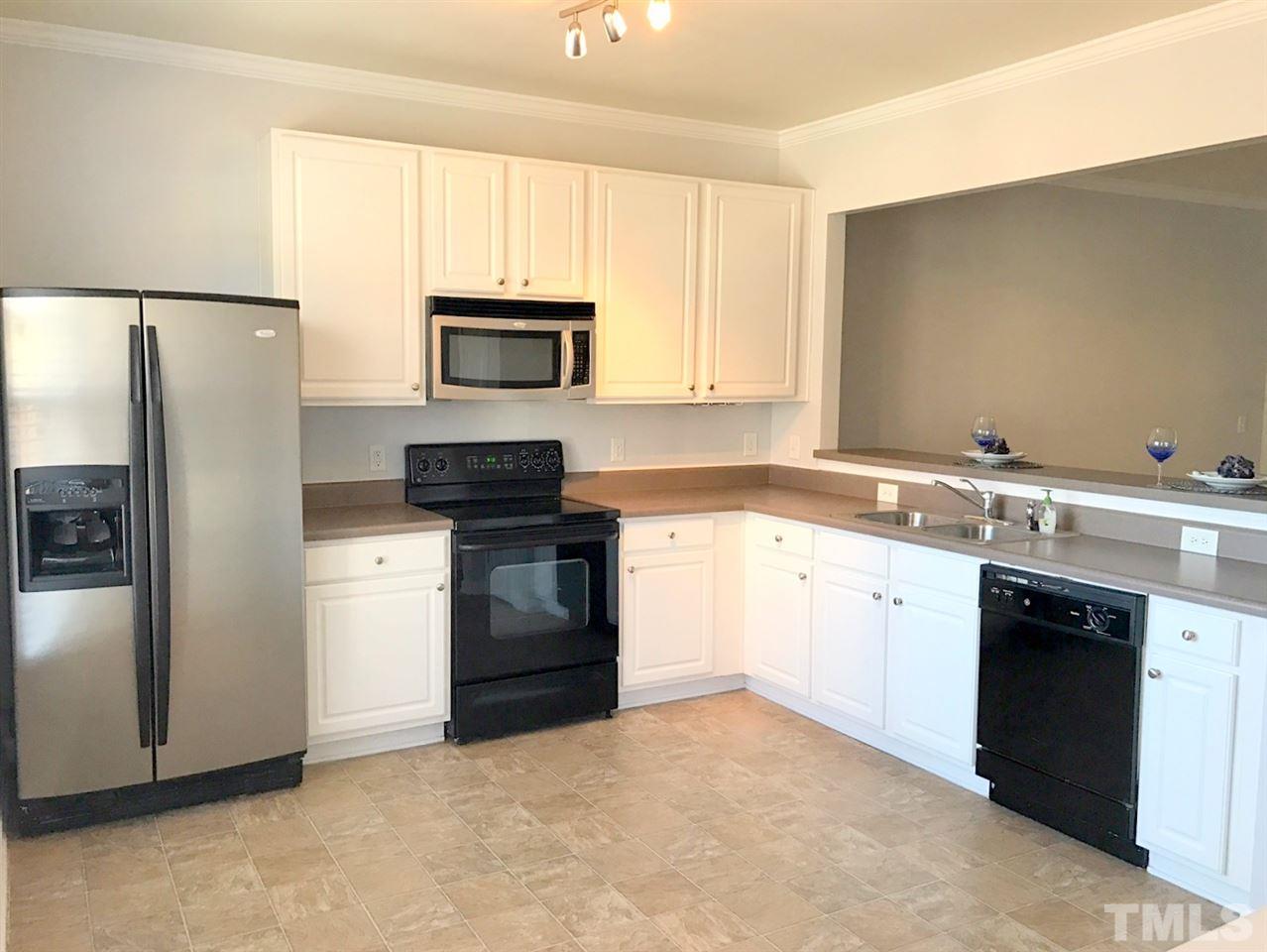 8511 Mt Valley Lane Raleigh, NC 27613 - Photo 6 of 25 a kitchen with a refrigerator sink and microwave