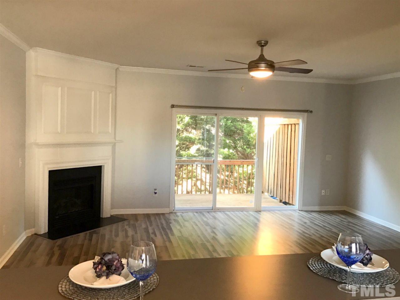 8511 Mt Valley Lane Raleigh, NC 27613 - Photo 8 of 25 a living room with hard wood floor a fireplace and a large window
