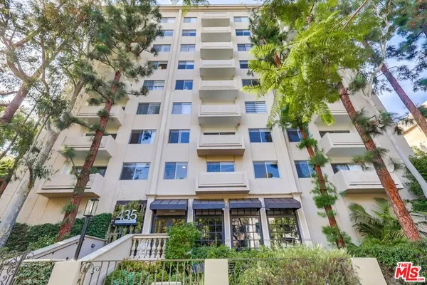 front view of a multi story residential apartment building with a yard