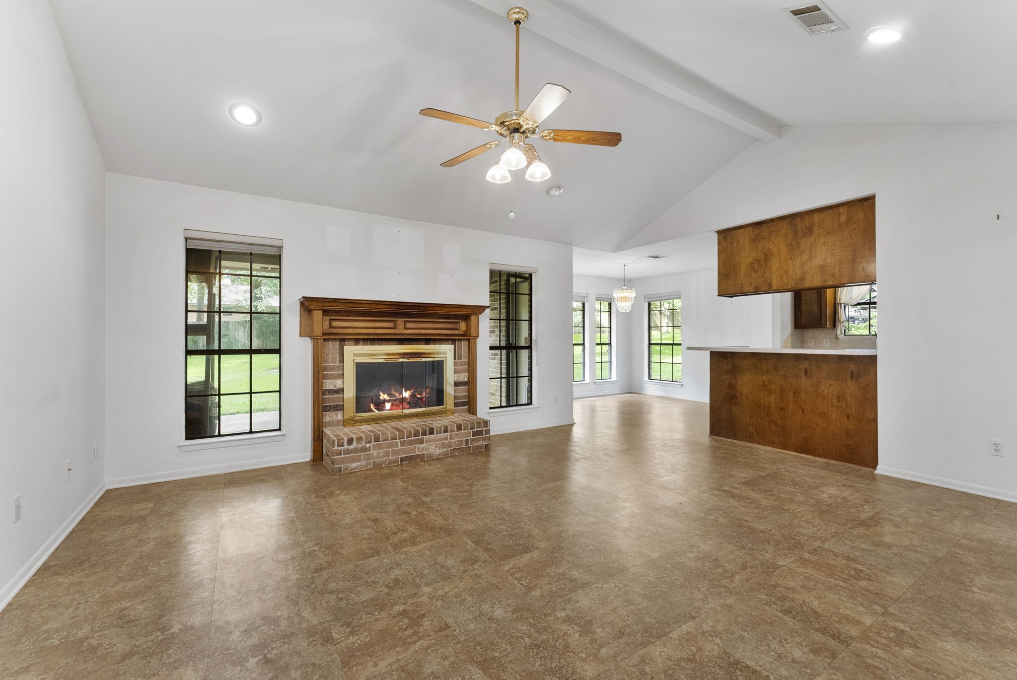 202 Sunset Boulevard Conroe, TX 77303 - Photo 8 of 50 This inviting family room features a stunning vaulted ceiling, creating an airy and spacious atmosphere perfect for relaxation and gatherings.