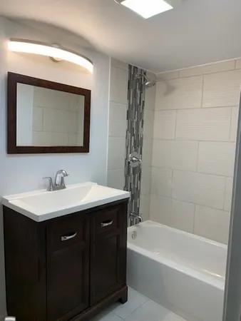 a bathroom with a sink a bathtub and a mirror