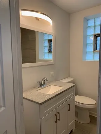 a bathroom with a toilet sink and mirror