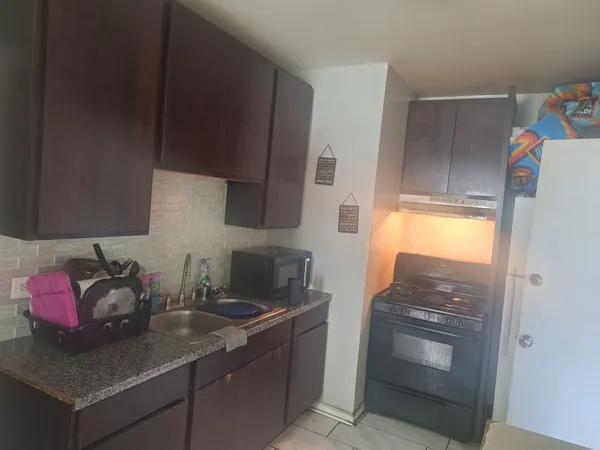 a kitchen with stainless steel appliances granite countertop a sink stove and cabinets