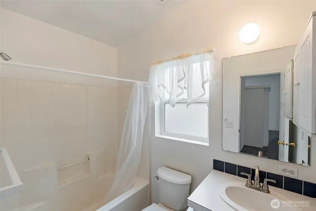 a bathroom with a sink toilet a mirror and shower