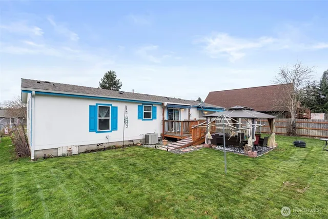 a white house with a big yard and potted plants in front of it