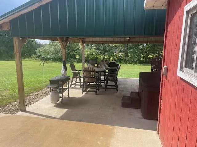 a view of a patio with table and chairs potted plants and floor to ceiling window
