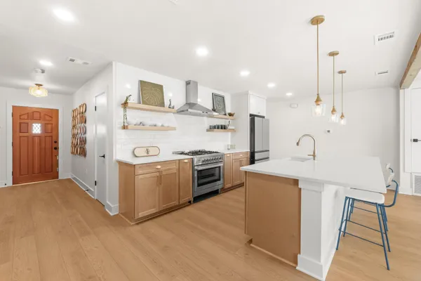 a kitchen with stainless steel appliances kitchen island a sink and a refrigerator