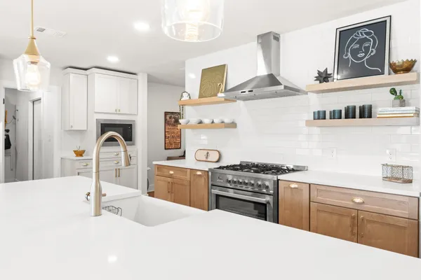 a kitchen with kitchen island granite countertop a stove and a sink