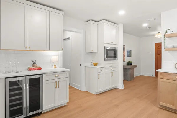 a kitchen with stainless steel appliances white cabinets and a refrigerator