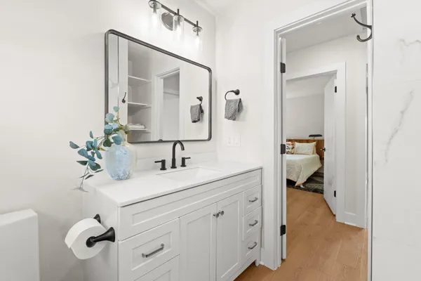 a en suite bathroom with a granite countertop sink and a mirror