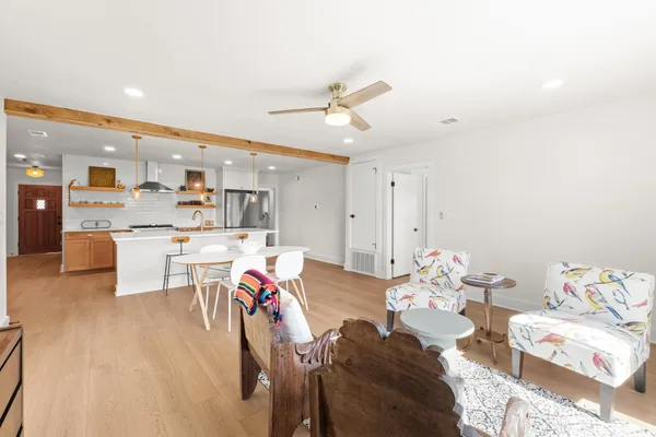 a living room with kitchen island furniture and a chandelier