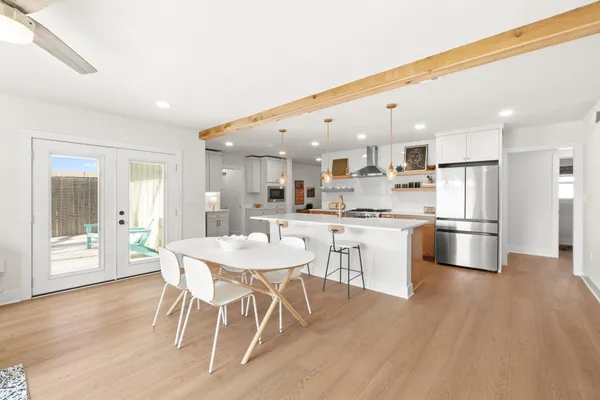 a kitchen with stainless steel appliances kitchen island granite countertop a table chairs sink and cabinets