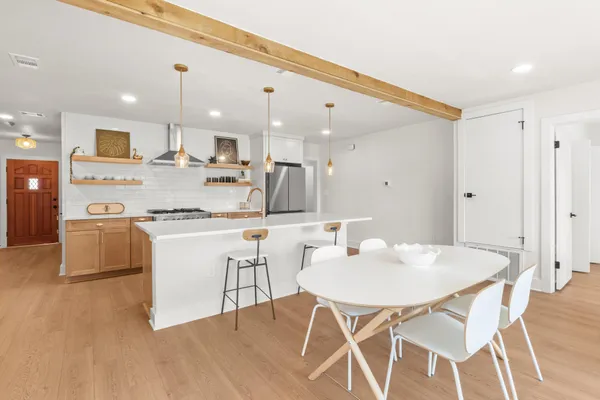 a kitchen with kitchen island stainless steel appliances a dining table and chairs