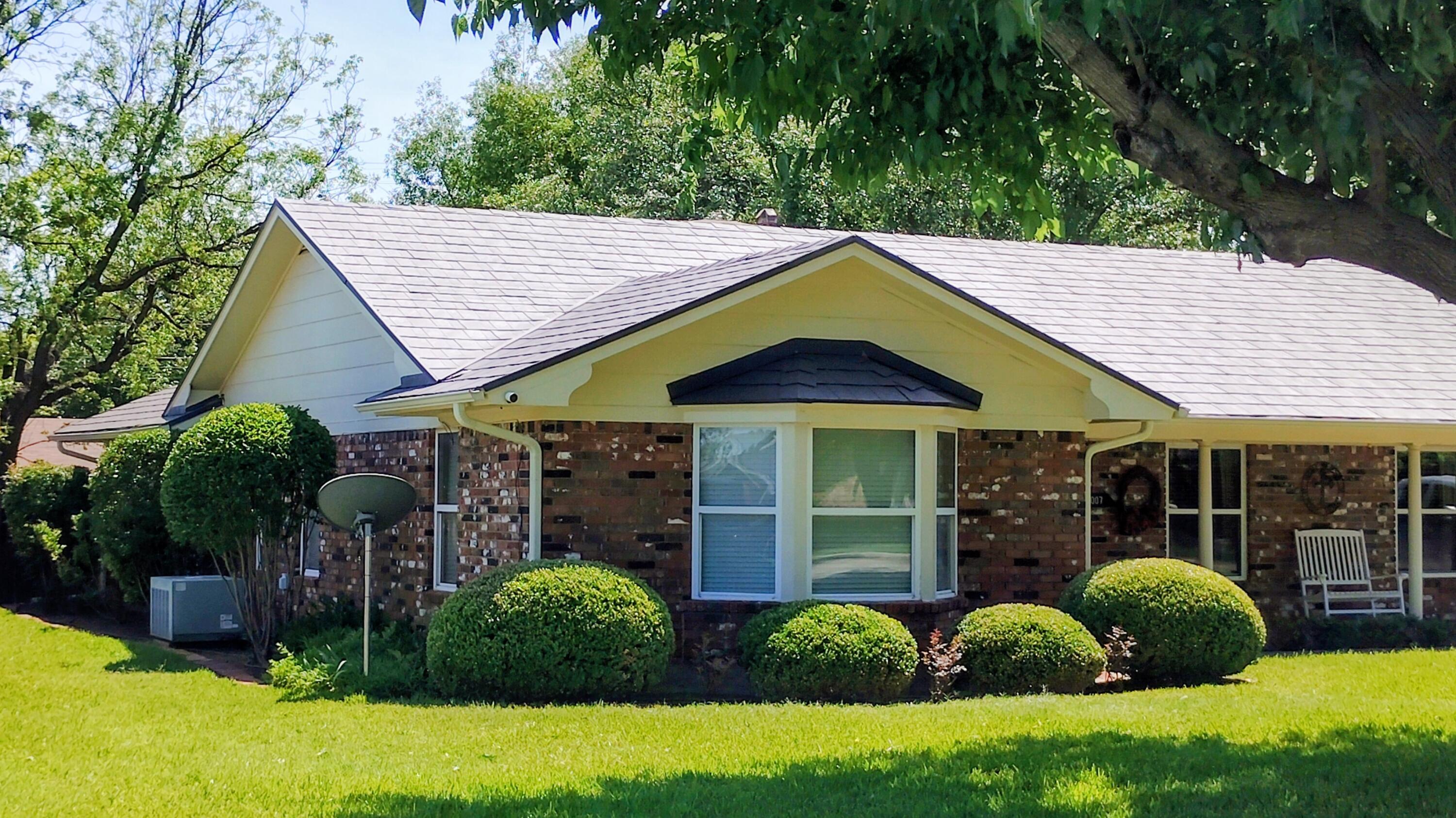 1007 West Edwards Street Olney, TX 76374 - Photo 2 of 3 a view of a house with a small yard plants and large tree
