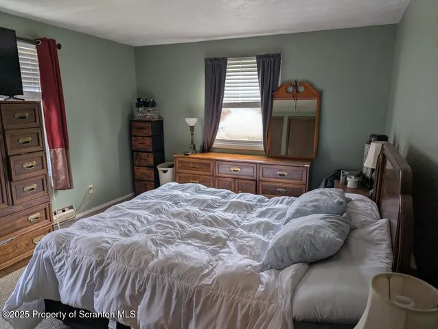 a bedroom with a bed and a television