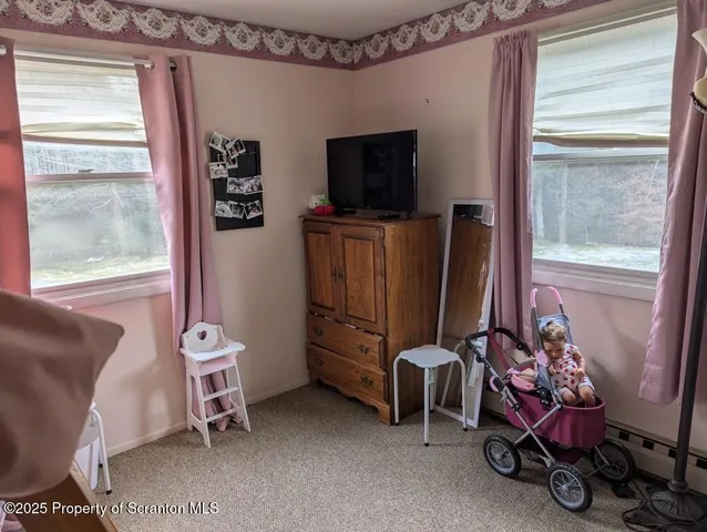 a living room with furniture a flat screen tv and a window
