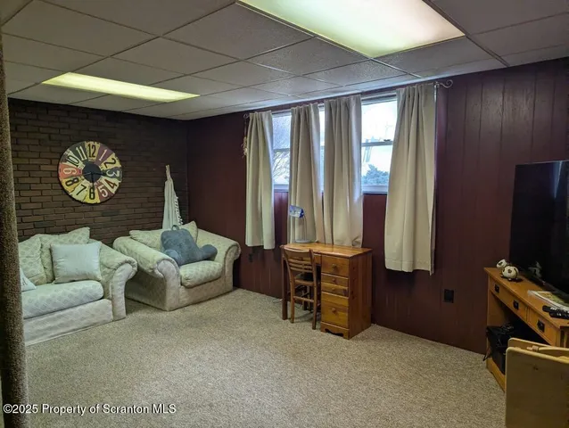 a living room with furniture a bookshelf and a flat screen tv