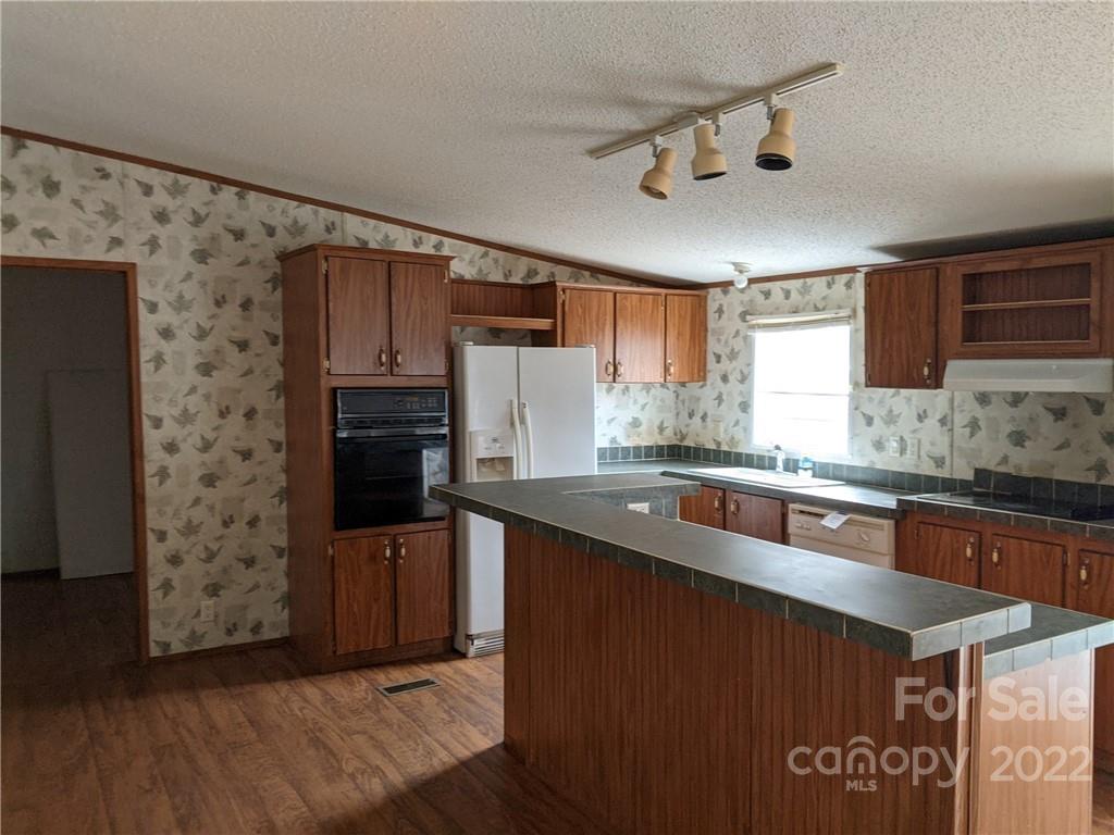 1449 State Rd S-28-313 Cassatt, SC 29032 - Photo 3 of 13 a kitchen with stainless steel appliances granite countertop a refrigerator a sink dishwasher a stove and a microwave oven on the wooden floor