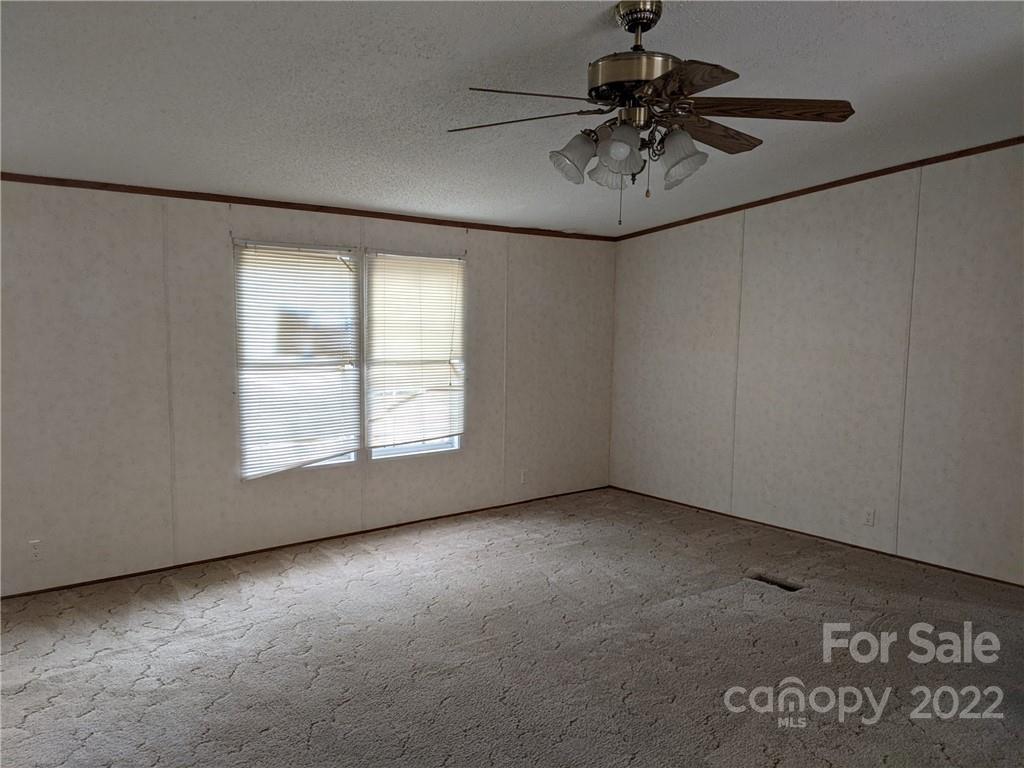 1449 State Rd S-28-313 Cassatt, SC 29032 - Photo 7 of 13 an empty room with a ceiling fan and a window