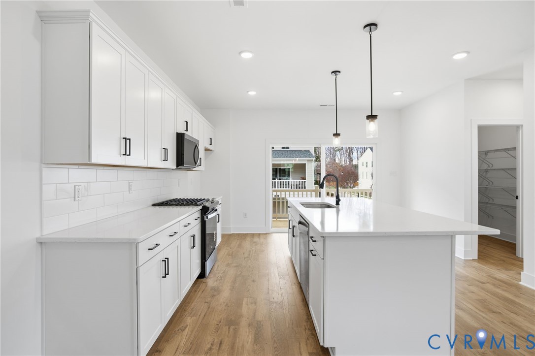 12016 Afternoon Path Henrico, VA 23233 - Photo 12 of 36 a large kitchen with stainless steel appliances kitchen island granite countertop a sink a stove and a wooden floors