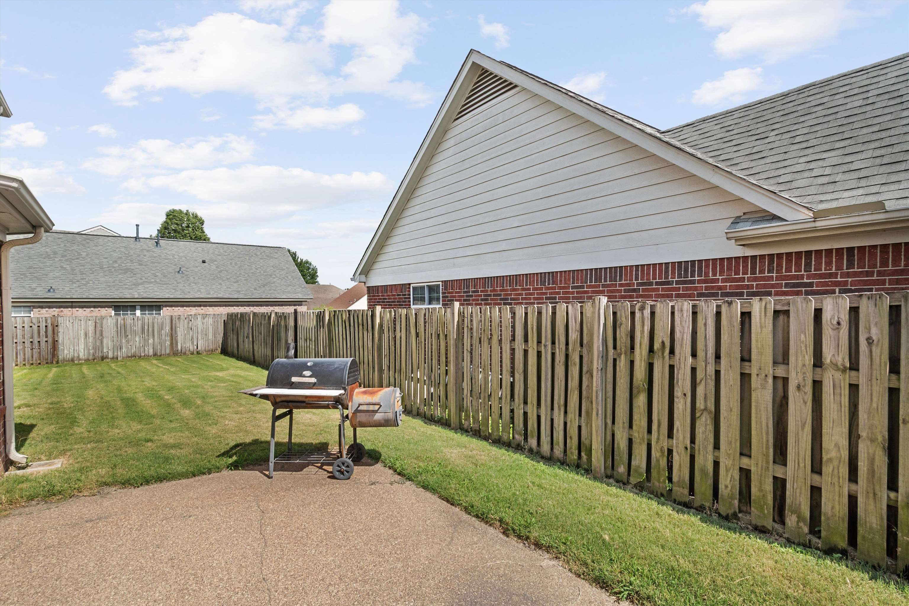 7779 Windy Willow Road Memphis, TN 38125 - Photo 25 of 30 Spacious backyard featuring a concrete patio, expansive lawn, and wood privacy fencing