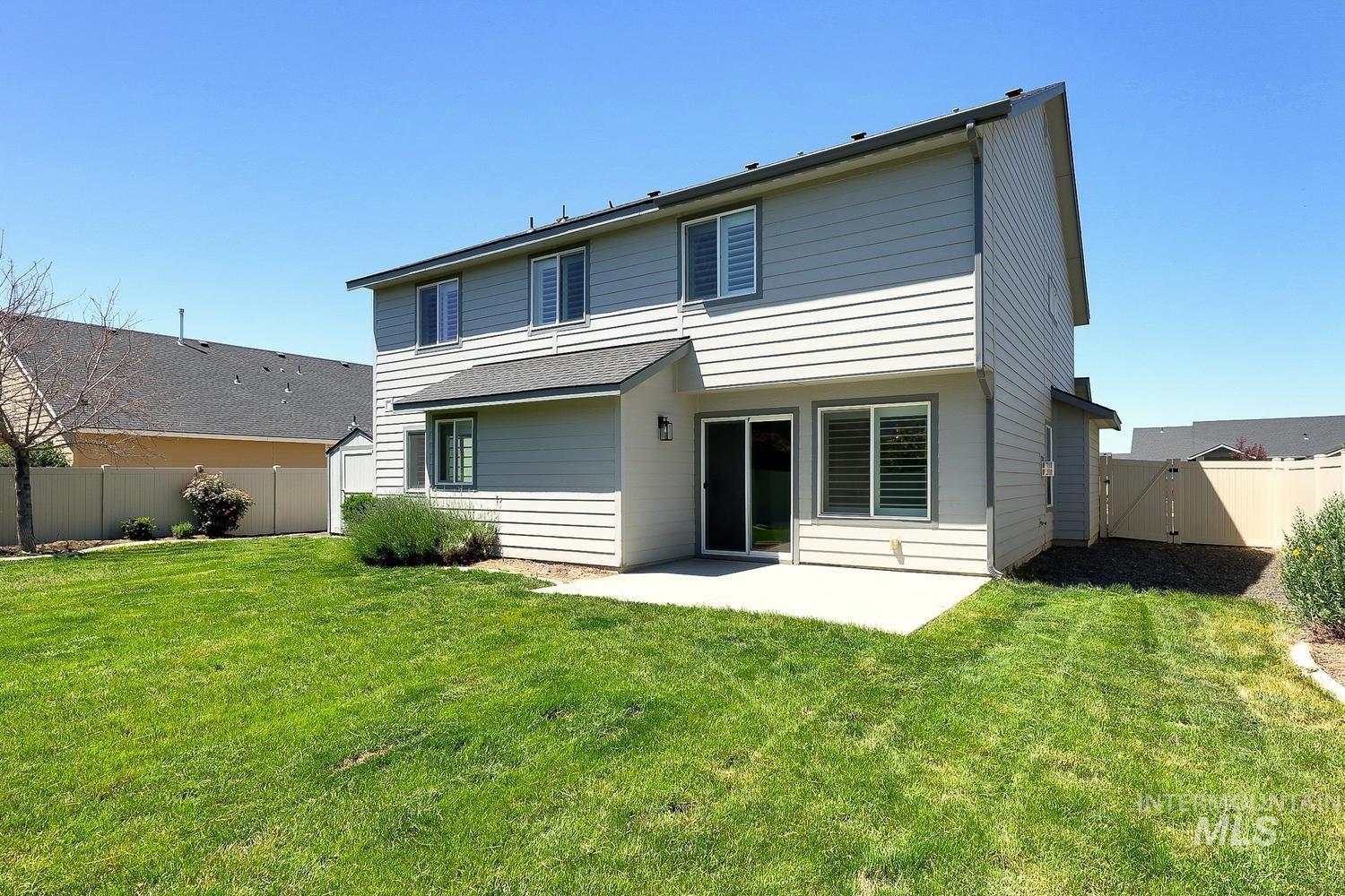 846 North Hidden View Way Star, ID 83669 - Photo 48 of 49 Rear exterior featuring a concrete patio, sliding glass door, and multiple windows with plantation shutters