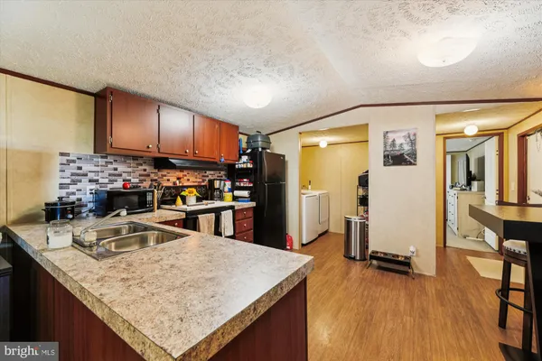a kitchen with stainless steel appliances granite countertop a sink refrigerator and cabinets