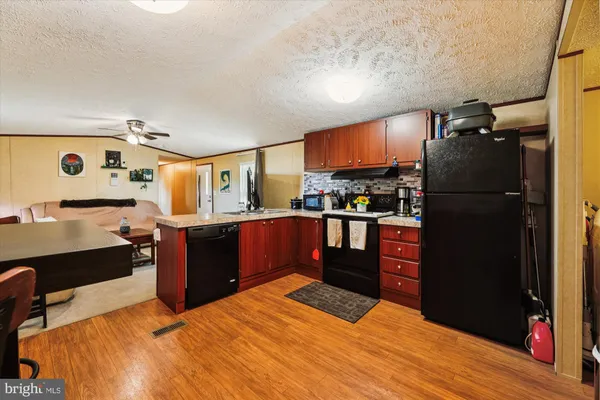 a kitchen with stainless steel appliances kitchen island granite countertop a refrigerator and a stove top oven