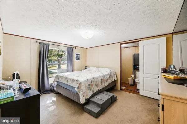 a spacious bedroom with a bed and a window