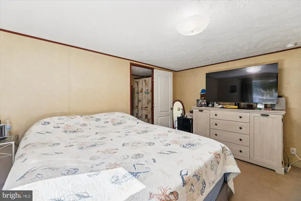 a bedroom with a bed and flat screen tv