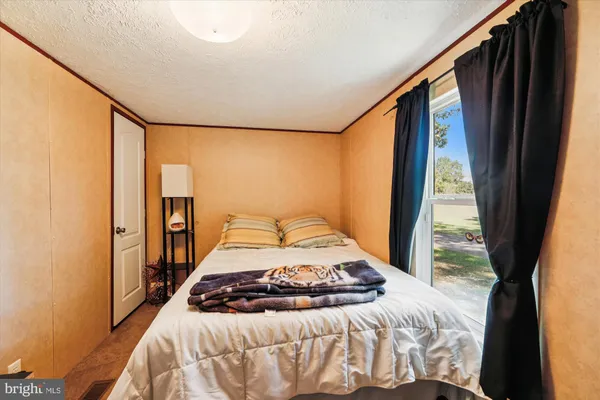 a bedroom with a bed and a large window