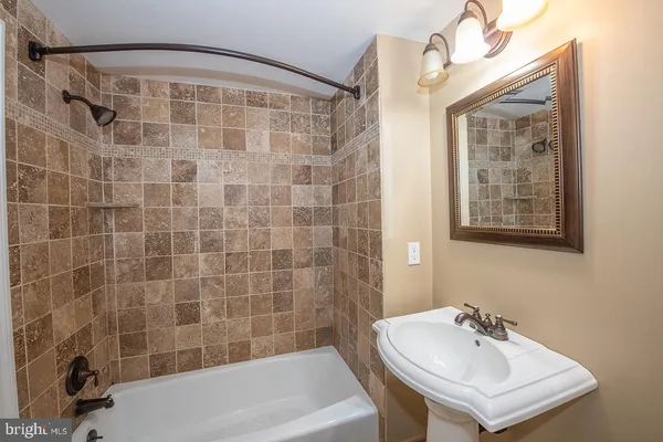 a bathroom with a sink a bathtub and shower