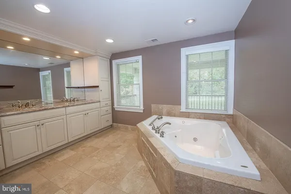 a large kitchen with kitchen island a large window a sink and stainless steel appliances