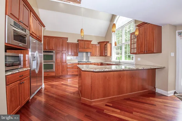 a kitchen with stainless steel appliances granite countertop a stove a sink and a refrigerator