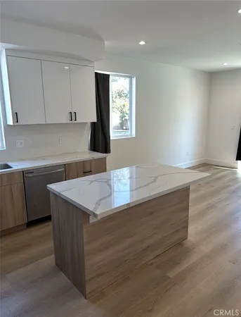 a kitchen with granite countertop white cabinets a sink and dishwasher