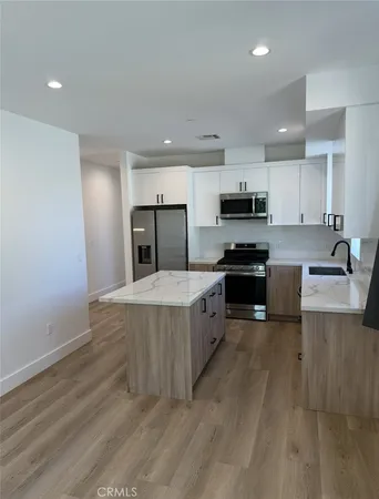 a large kitchen with stainless steel appliances granite countertop a stove a sink and a refrigerator