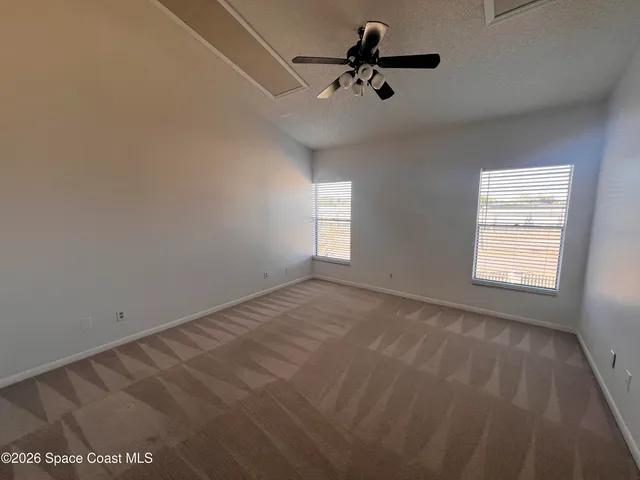an empty room with a window and a fan