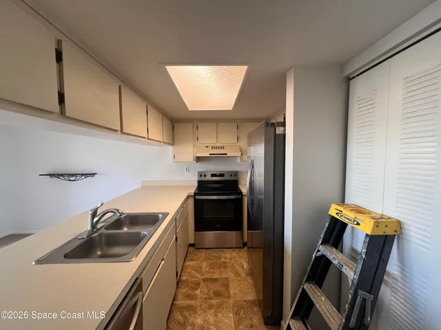 a kitchen with a sink cabinets and stainless steel appliances