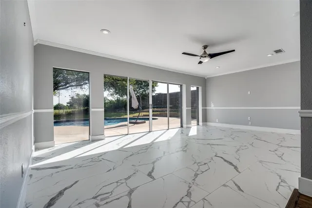 a view of an empty room with a window and a ceiling fan